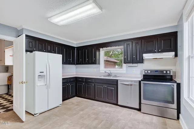a kitchen with stainless steel appliances granite countertop a stove sink and refrigerator