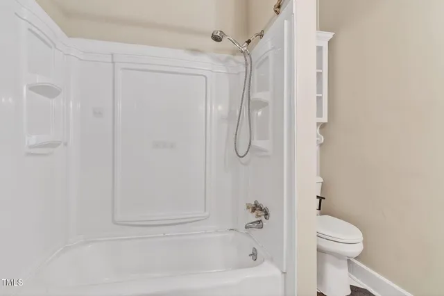 a bathroom with a shower a toilet and a shower