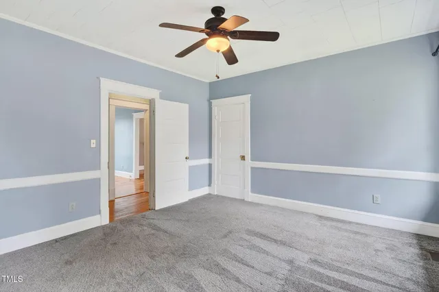 a view of a room with an empty space and a ceiling fan