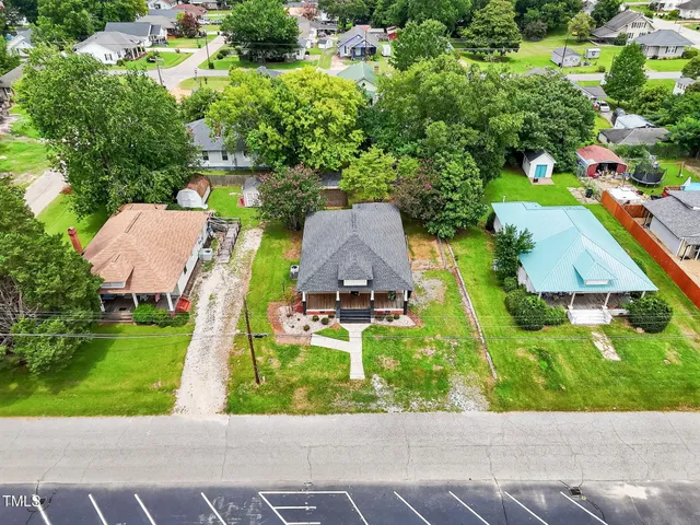 an aerial view of a house with a yard and lake view