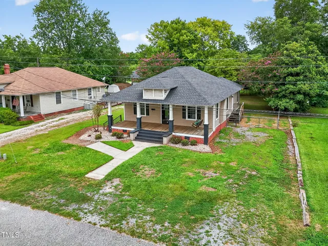 a aerial view of a house with a yard table and chairs