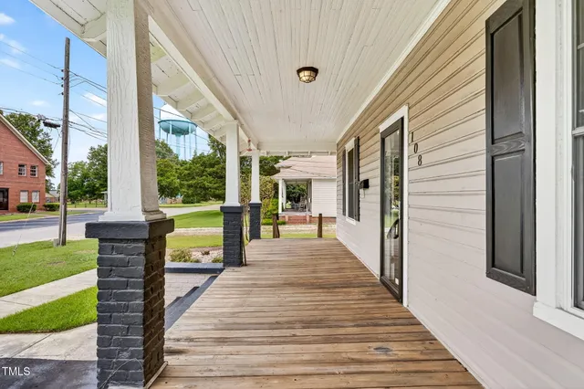 a view of a porch with wooden floor and floor to ceiling window