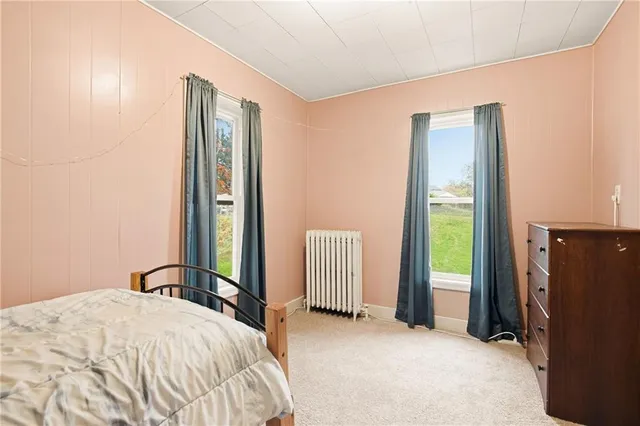 a bedroom with a bed and a refrigerator