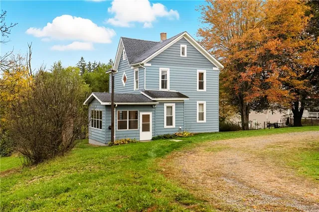 a view of a house with a yard and fence