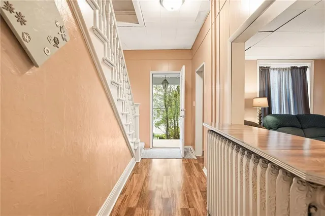 a view of a hallway with wooden floor and staircase