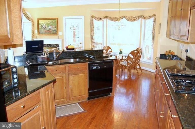 154 Rees Place Falls Church, VA 22046 - Photo 6 of 21 a kitchen with stainless steel appliances granite countertop a stove and wooden floor