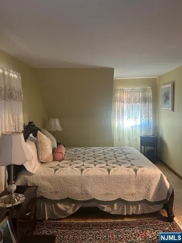 a bedroom with a bed and lamp on desk