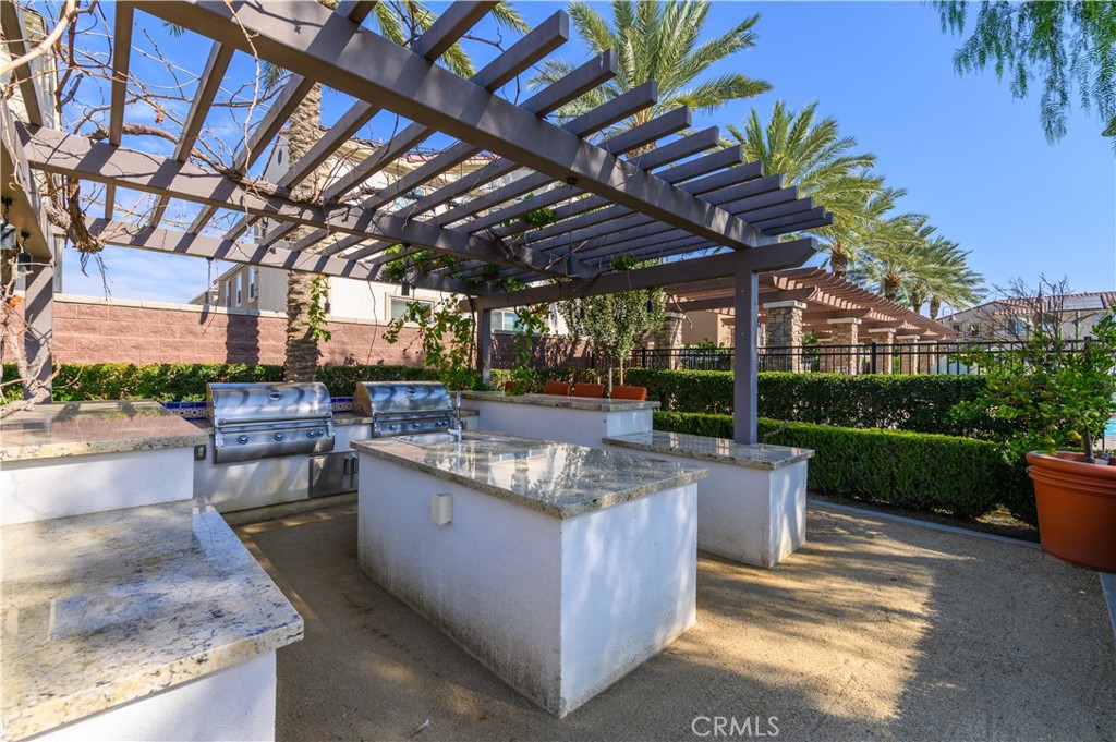 8825 Celebration Street Chino, CA 91708 - Photo 19 of 30 a view of a patio with table and chairs potted plants and palm tree