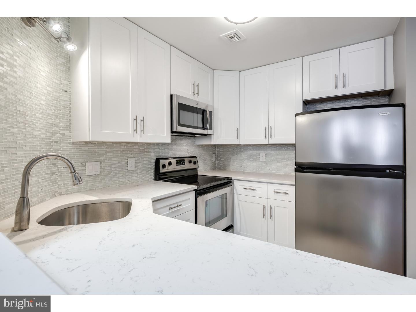 12-16 Letitia Street, Unit 503 Philadelphia, PA 19106 - Photo 2 of 12 a kitchen with stainless steel appliances granite countertop a refrigerator sink and white cabinets