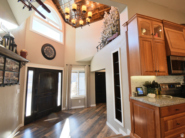 656 South Bullion Canyon Road Marysvale, UT 84750 - Photo 5 of 57 Foyer featuring healthy amount of natural light, wood ceiling, dark wood finished floors, a high ceiling, built in ladder leading to "reading nook", and a chandelier