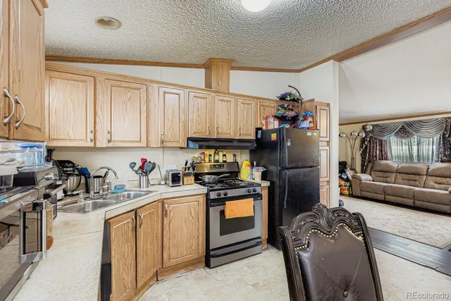 a kitchen with stainless steel appliances granite countertop a refrigerator sink and stove