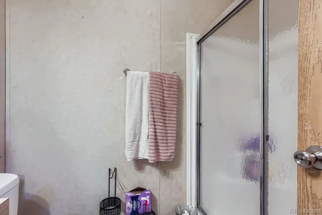 a bathroom with a shower and a chair