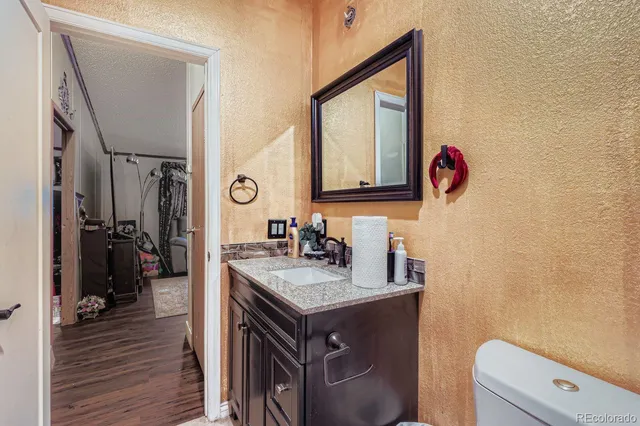 a bathroom with a granite countertop sink a mirror and vanity