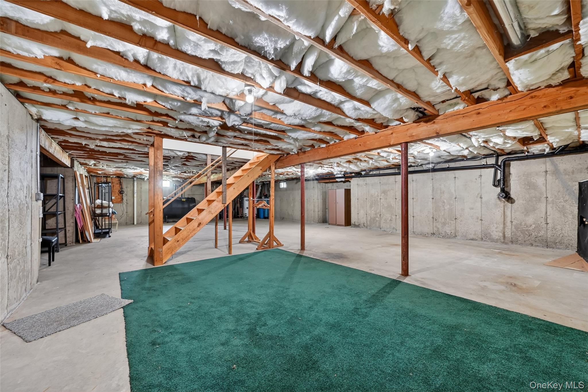 19 Bull Mine Road Chester, NY 10918 - Photo 35 of 42 Unfinished basement featuring exposed wood joists with insulation, concrete slab flooring, and a partial green carpet area