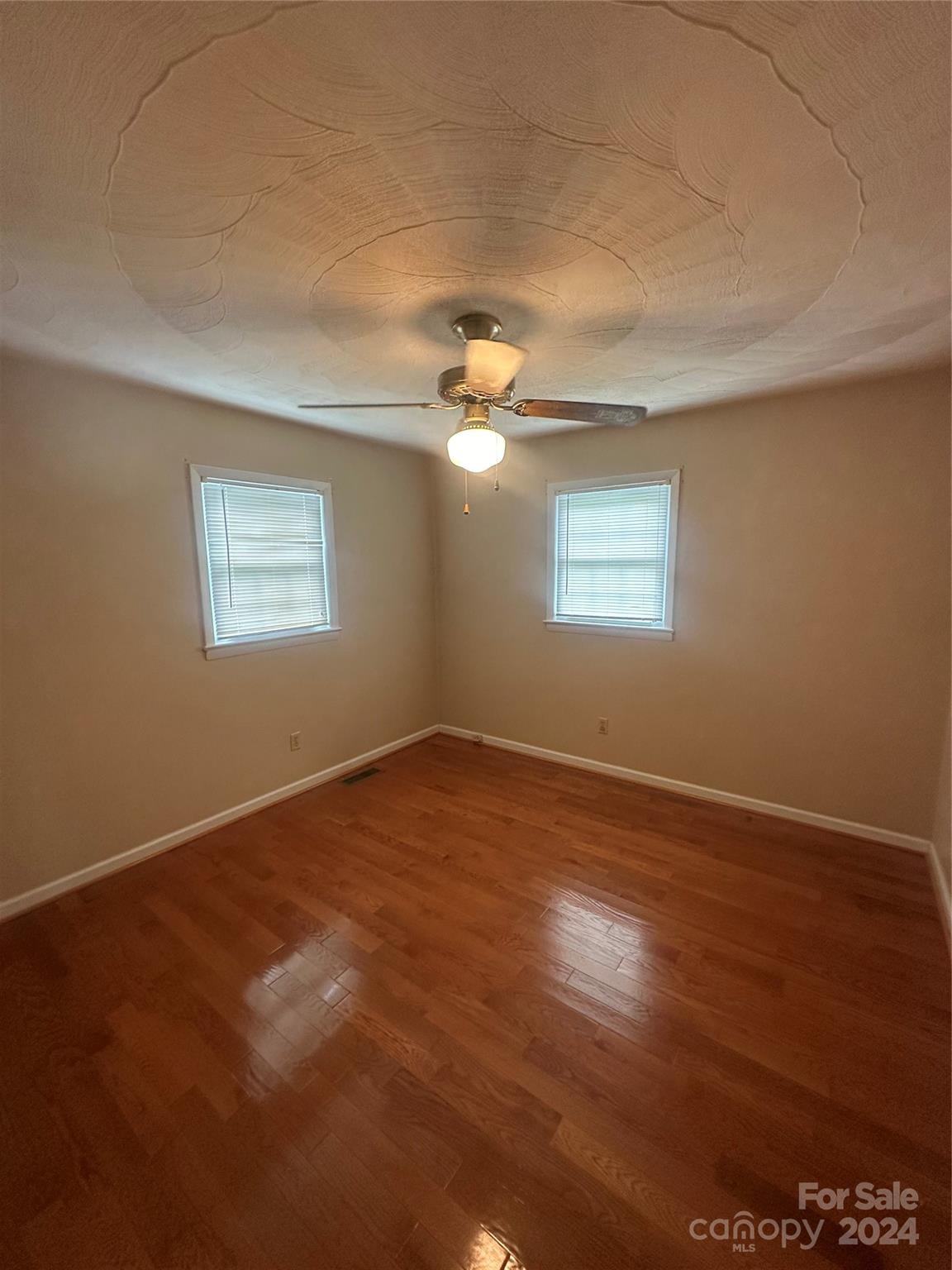 1854 Holland Drive Conover, NC 28613 - Photo 11 of 14 an empty room with wooden floor and windows
