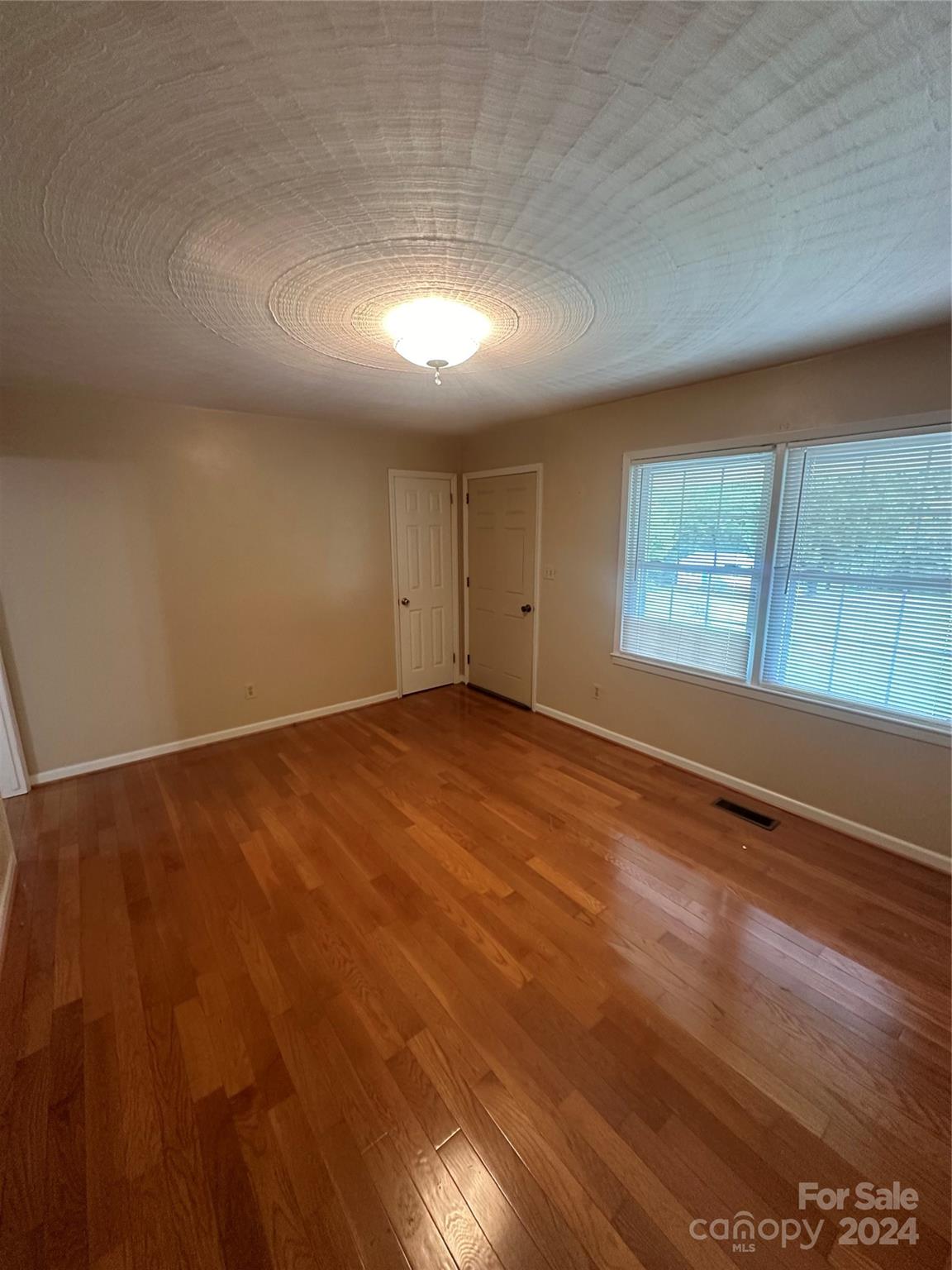 1854 Holland Drive Conover, NC 28613 - Photo 7 of 14 an empty room with wooden floor and windows