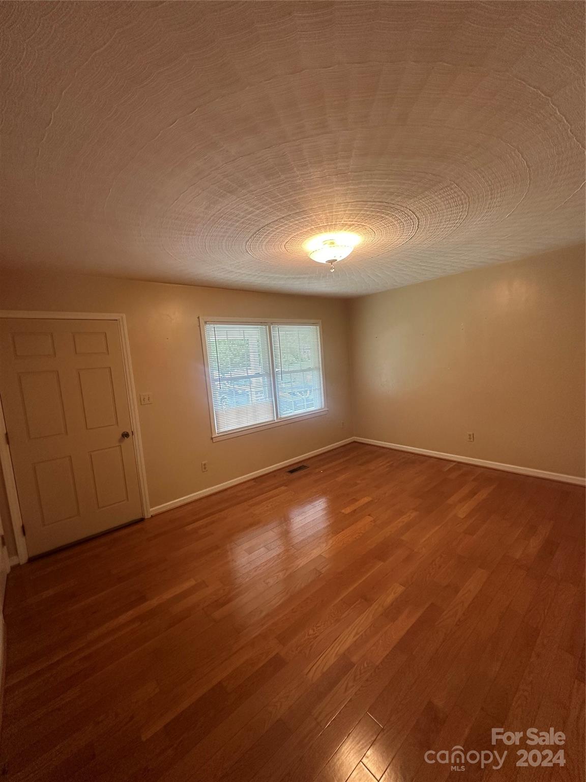 1854 Holland Drive Conover, NC 28613 - Photo 9 of 14 an empty room with wooden floor and windows