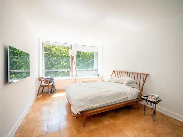 a bed sitting in a bedroom next to a window