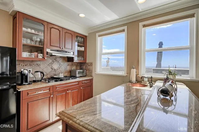 a kitchen with a stove a sink and cabinets