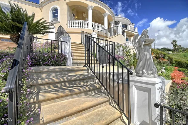 a view of a brick house with many windows and a tree