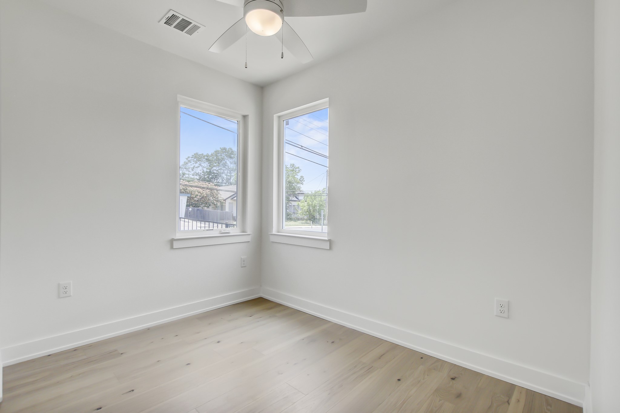 4127 East 12th Street, Unit 8 Austin, TX 78721 - Photo 22 of 32 Spare room featuring ceiling fan, baseboards, and light wood finished floors