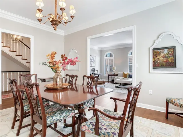a living room with stainless steel appliances furniture a rug and a kitchen view