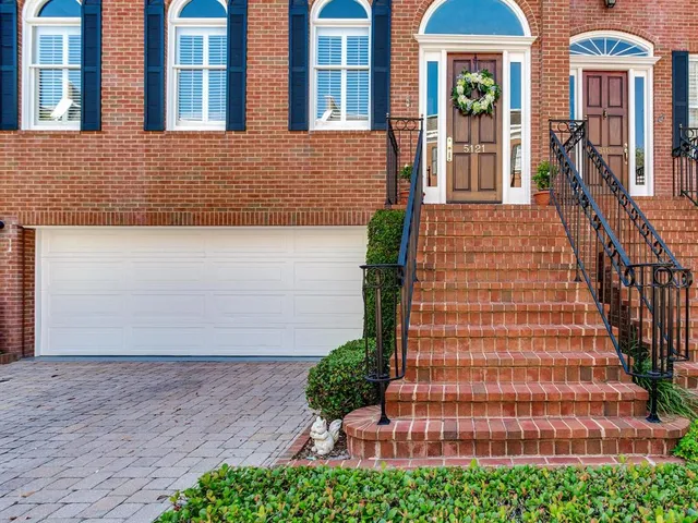 a view of staircase with lots of frames on wall and a window
