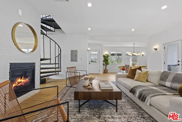 a living room with furniture a fireplace and a chandelier