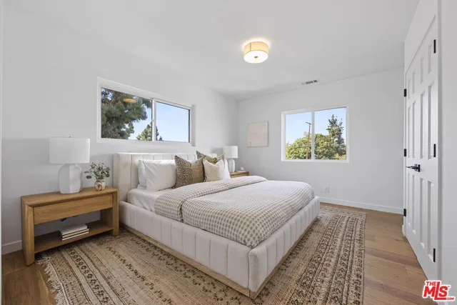 a bedroom with a bed and a painting on the wall