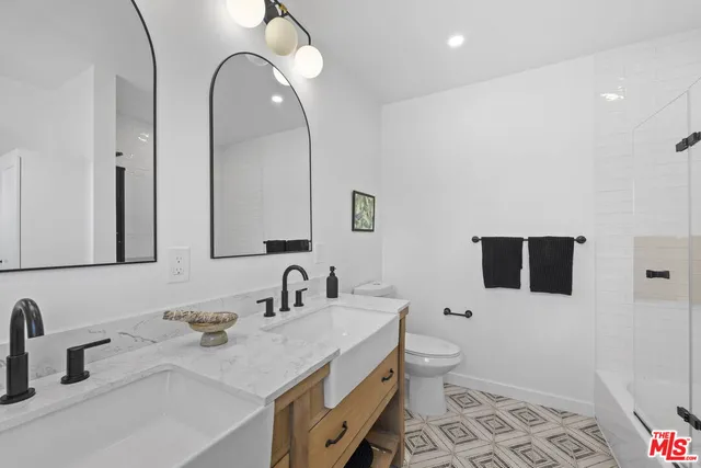 a bathroom with a double vanity sink and mirror
