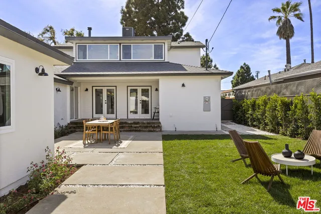 a view of a house with backyard sitting area and garden