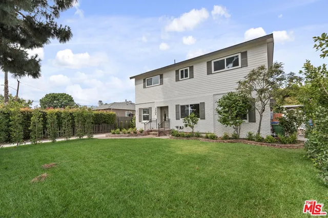 a view of a house with a yard and sitting area