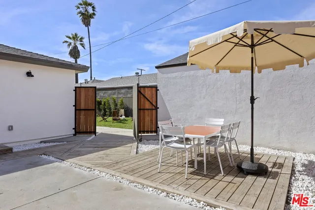 a view of a roof deck with table and chairs under an umbrella