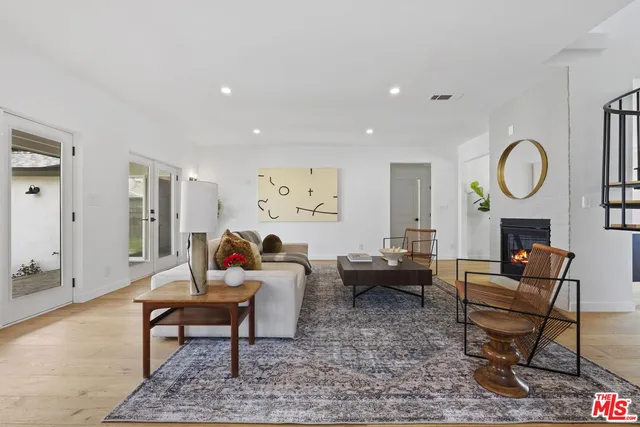 a living room with fireplace furniture and a rug