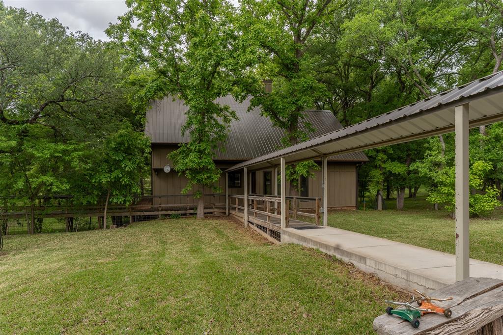 377 County Road 2530 Meridian, TX 76665 - Photo 22 of 25 a backyard of a house with plants and large tree
