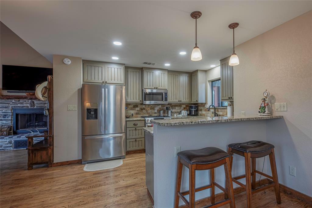 377 County Road 2530 Meridian, TX 76665 - Photo 9 of 25 a kitchen with stainless steel appliances granite countertop a refrigerator a sink and a stove