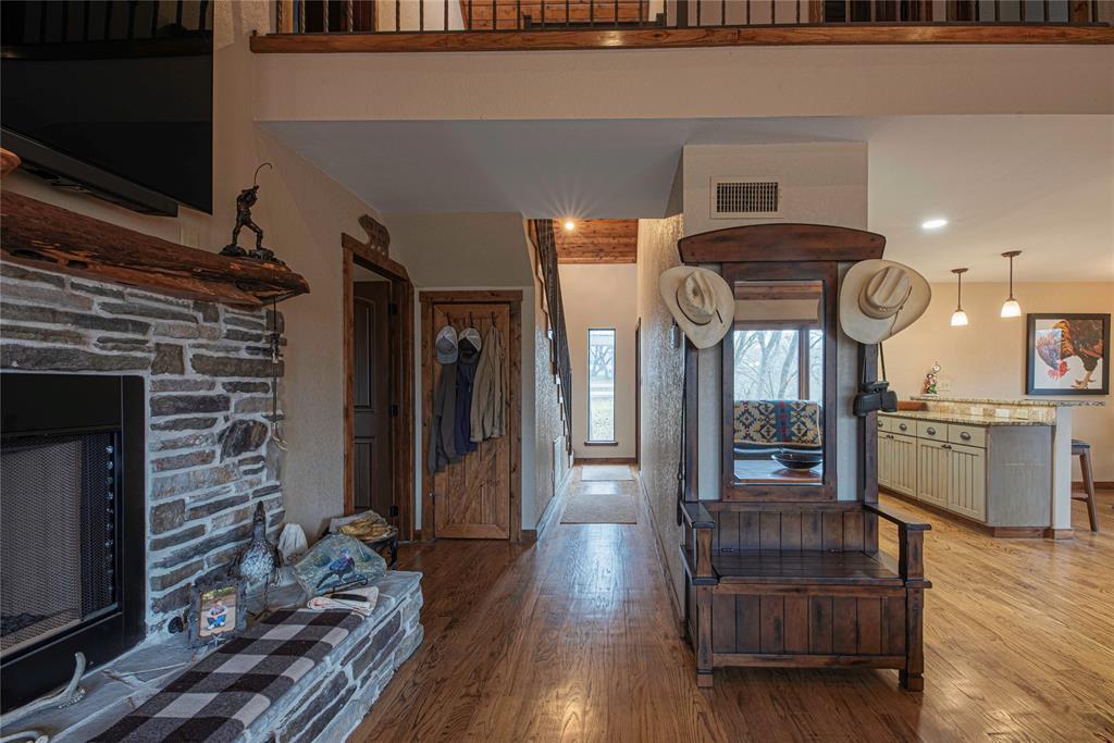 377 County Road 2530 Meridian, TX 76665 - Photo 10 of 25 a view of hallway with wooden floor and fireplace