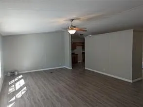 a view of empty room with wooden floor and ceiling fan
