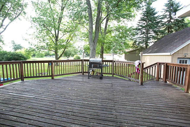 a view of a deck with wooden chairs and table and chairs