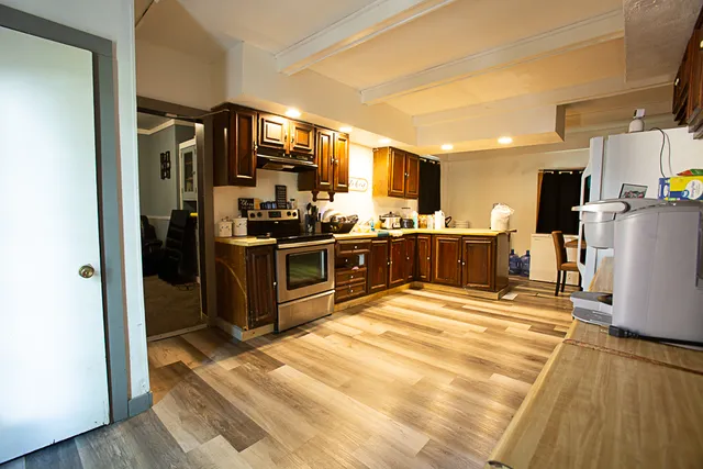 a kitchen with stainless steel appliances kitchen island granite countertop a refrigerator and a stove top oven