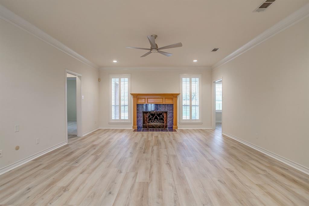 125 View Point Court Aledo, TX 76008 - Photo 11 of 34 an empty room with fireplace wooden floor chandelier fan and windows