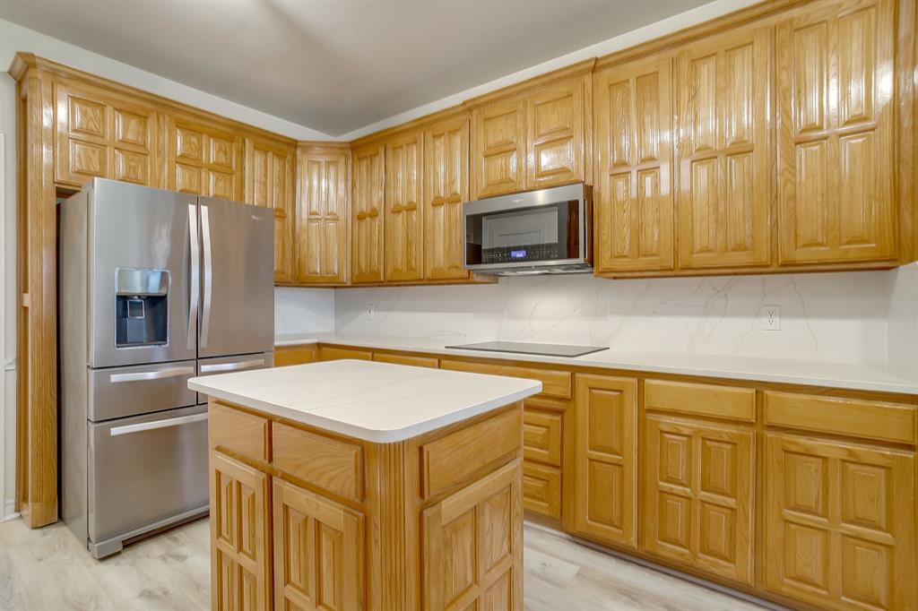 125 View Point Court Aledo, TX 76008 - Photo 15 of 34 a kitchen with stainless steel appliances granite countertop a refrigerator a stove a sink dishwasher and wooden cabinets with wooden floor