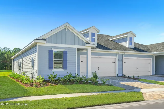 a front view of a house with a garden and plants