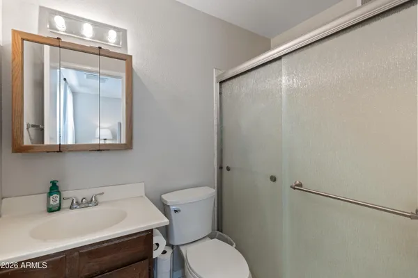 a bathroom with a sink vanity mirror and toilet