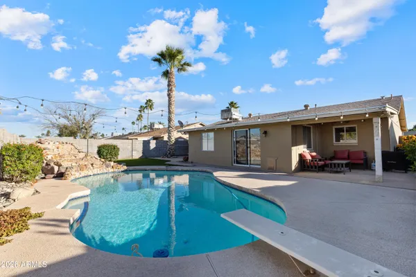 a view of a house with swimming pool and sitting area