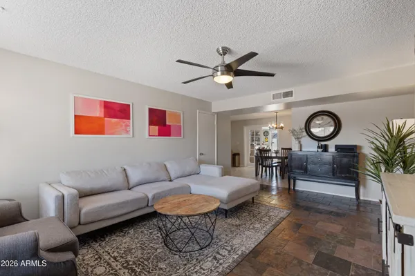 a living room with furniture a clock and a ceiling fan