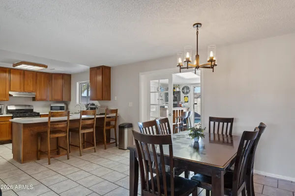a view of a dining room and livingroom with furniture wooden floor a chandelier