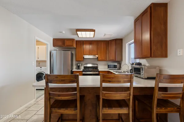 a kitchen with granite countertop wooden cabinets and stainless steel appliances