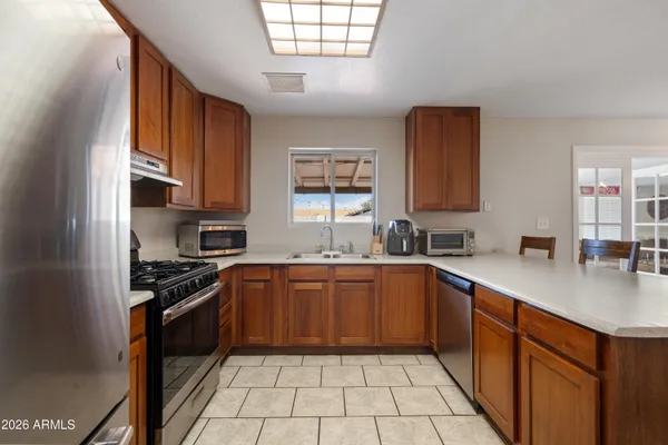 a kitchen with stainless steel appliances granite countertop a sink counter space cabinets and a window