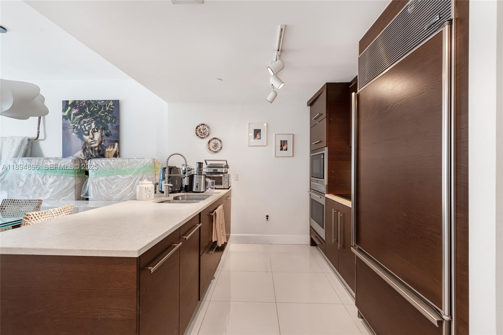 475 Brickell Avenue, Unit 3111 Miami, FL 33131 - Photo 7 of 24 a kitchen with kitchen island a counter top space and stainless steel appliances